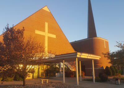 A church with a cross in front of it.