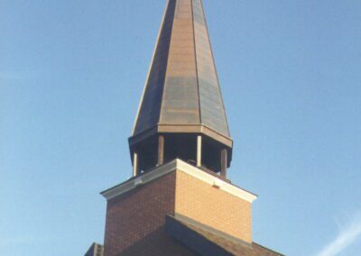 A brick building with a cross on top.