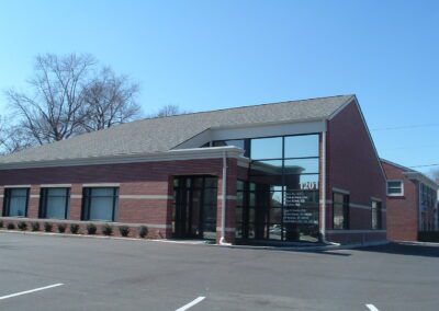 A brick building with a parking lot in front of it.